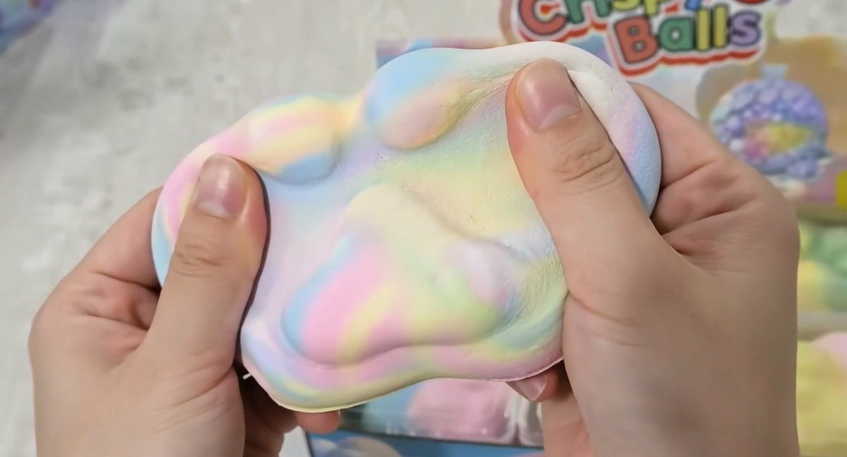 Hand squeezing rainbow cat paw